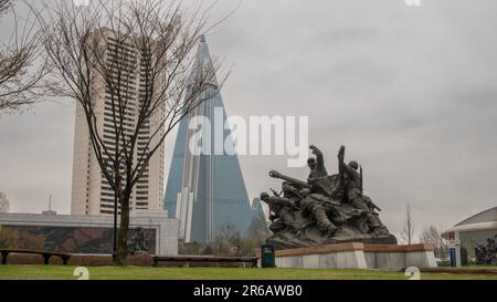 Pjöngjang, Nordkorea (Demokratische Volksrepublik Korea). April 2018. Victorious war Museum mit Ryugyong Hotel im Hintergrund. Stockfoto