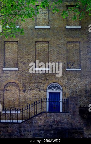 Ein elegantes georgianisches Londoner Stadthaus mit einer blauen Eingangstür eine Treppe hoch und alle Fenster sind versteinert - Stil oder Fenstersteuer? Stockfoto