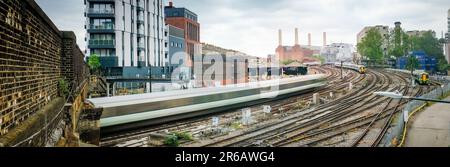 Panoramablick auf einen Zug, der in London Victoria Station ankommt, mit Battersea Kraftwerk im Hintergrund Stockfoto