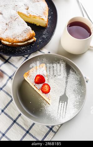 Ein Stück Kuchen Karpatka auf dem Teller. Traditioneller polnischer Kuchen Karpatka auf grauem Betonhintergrund. Cream Puff Cake 'Carpathian Mountain' mit Vanille Stockfoto
