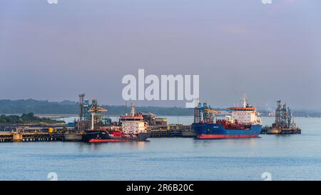 Sonnenaufgang über Gasschiffen und Esso Oil Terminal, Southampton, Hampshire, England Stockfoto