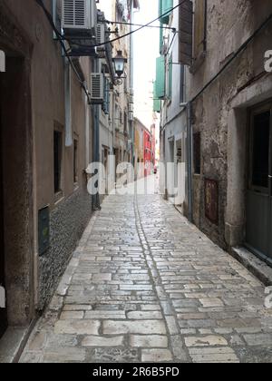 Eine malerische Gasse zwischen zwei Gebäuden in einer Stadt, die ins Unbekannte führt Stockfoto