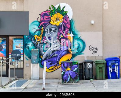 Toronto, Kanada - 4. Juni 2023: Ein Kunstporträt einer Frau an der Wand. Ein Vogel steht auf der Hand der Frau. Stockfoto