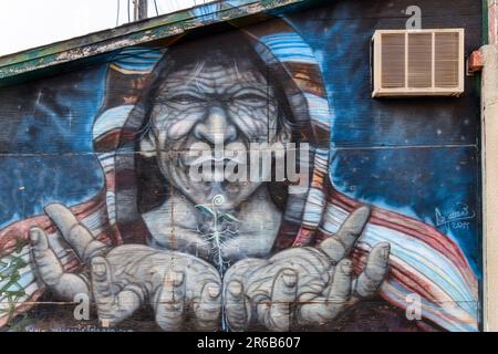 Toronto, Kanada - 4. Juni 2023: Kensington Market. Kunstporträt eines Kapuzenmannes mit ausgestreckten Handflächen. Stockfoto