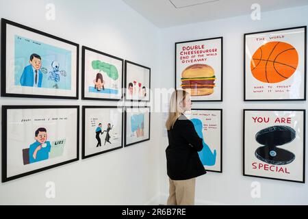 London, Großbritannien. 8. Juni 2023 Ein Mitarbeiter sieht sich Drucke in einer Vorschau von Werken in einer eigenständigen Online-Auktion an, die für Werke von David Shrigley vorgesehen ist, einschließlich Werken auf Papier, Drucke und Kombiwetten. Die Auktion findet am Phillips.com vom 7. Bis 14. Juni statt, wobei vom 10. Bis 12. Juni in den Londoner Galerien von Phillips auf dem Berkeley Square die wichtigsten Verkaufspunkte zu sehen sind. Kredit: Stephen Chung / Alamy Live News Stockfoto