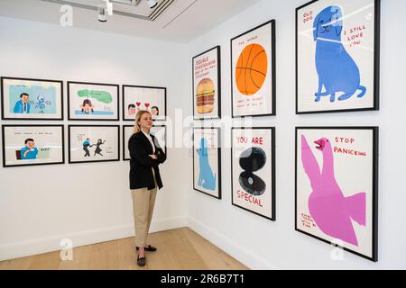 London, Großbritannien. 8. Juni 2023 Ein Mitarbeiter sieht sich Drucke in einer Vorschau von Werken in einer eigenständigen Online-Auktion an, die für Werke von David Shrigley vorgesehen ist, einschließlich Werken auf Papier, Drucke und Kombiwetten. Die Auktion findet am Phillips.com vom 7. Bis 14. Juni statt, wobei vom 10. Bis 12. Juni in den Londoner Galerien von Phillips auf dem Berkeley Square die wichtigsten Verkaufspunkte zu sehen sind. Kredit: Stephen Chung / Alamy Live News Stockfoto