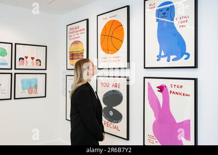 London, Großbritannien. 8. Juni 2023 Ein Mitarbeiter sieht sich Drucke in einer Vorschau von Werken in einer eigenständigen Online-Auktion an, die für Werke von David Shrigley vorgesehen ist, einschließlich Werken auf Papier, Drucke und Kombiwetten. Die Auktion findet am Phillips.com vom 7. Bis 14. Juni statt, wobei vom 10. Bis 12. Juni in den Londoner Galerien von Phillips auf dem Berkeley Square die wichtigsten Verkaufspunkte zu sehen sind. Kredit: Stephen Chung / Alamy Live News Stockfoto