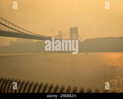 Manhattan, NY, USA, 07/06/2023, Rauch aus kanadischen Waldbränden färbt die Luft über der George Washington Bridge über dem Hudson River. Das Foto zeigt die Küste von New Jersey aus der Sicht von Upper Manhattan, NY, USA. Kredit: John Lazenby/Alamy Live News Stockfoto