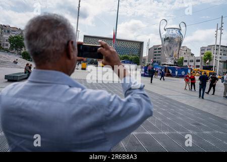 Ein Mann fotografiert das Modell der UEFA Champions League 2023 am Taksim Square. Manchester City und Inter Atatürk treffen sich im Olympiastadion im Endspiel, das insgesamt zum 68. Mal stattfindet und den Sieger der UEFA Champions League-Saison 2022-23 bestimmt. Im Rahmen der organisierten Veranstaltungen wurden auf Taksim, dem beliebtesten Platz von Istanbul, ein riesiger Champions League Cup und ein Modell des Fußballballs gezeigt, der für das speziell entworfene Spiel verwendet werden sollte. (Foto: Tunahan Turhan / SOPA Images/Sipa USA) Stockfoto