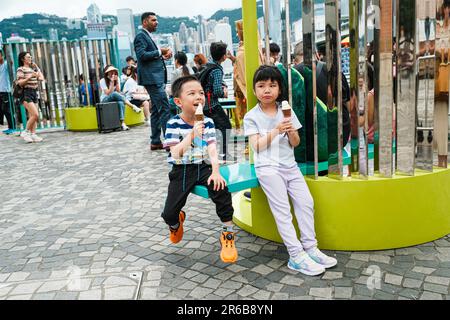 Hongkong, China. 8. Juni 2023. Kinder essen Eis und sitzen am Tsim Sha Tsui Star Fähranleger. (Kreditbild: © Keith Tsuji/ZUMA Press Wire) NUR REDAKTIONELLE VERWENDUNG! Nicht für den kommerziellen GEBRAUCH! Stockfoto