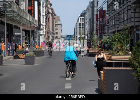 Berlin, Deutschland. 08. Juni 2023. Passanten laufen entlang der Friedrichstraße. Die bekannte Einkaufsstraße ist immer noch für den Durchgangsverkehr gesperrt. Aber das wird sich nächsten Monat ändern. Ab Juli dürfen Autos wieder auf der Straße fahren. Aber nur mit Vorbehalt: Im Herbst werden die Bewohner in der Zukunft der Straße ein Mitspracherecht haben. Kredit: Paul Zinken/dpa/Alamy Live News Stockfoto