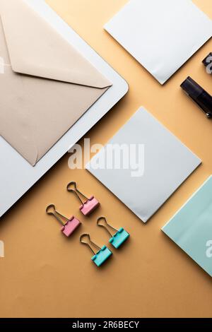 Flache Anordnung von schwarzen Stiften, Umschlägen, Büroklammern und Notizen mit Kopierbereich auf gelbem Hintergrund. Schulmaterial, Schreiben, Malen, Zeichnen, lear Stockfoto