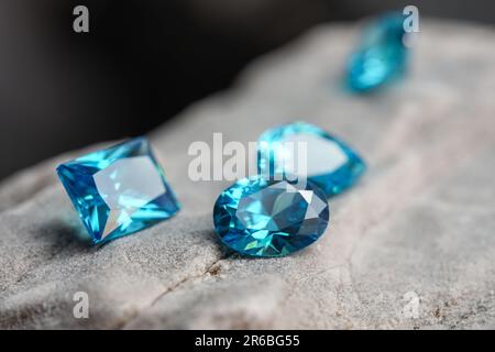 Die glitzernden natürlichen blauen Saphir-Edelsteine auf einer rauen Felsoberfläche Stockfoto