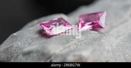 Die glitzernden natürlichen rosa Saphirsteine auf einer rauen Felsoberfläche Stockfoto