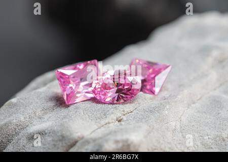 Die glitzernden natürlichen rosa Saphirsteine auf einer rauen Felsoberfläche Stockfoto