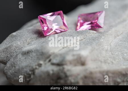 Die glitzernden natürlichen rosa Saphirsteine auf einer rauen Felsoberfläche Stockfoto