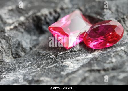 Die glitzernden natürlichen rosa Saphirsteine auf einer rauen Felsoberfläche Stockfoto