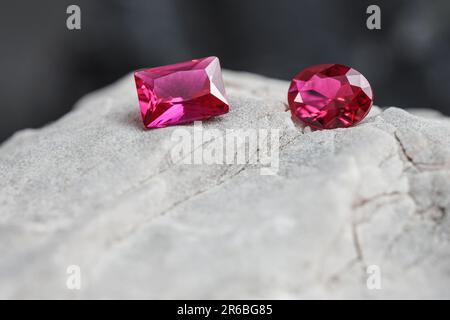 Die glitzernden natürlichen rosa Saphirsteine auf einer rauen Felsoberfläche Stockfoto