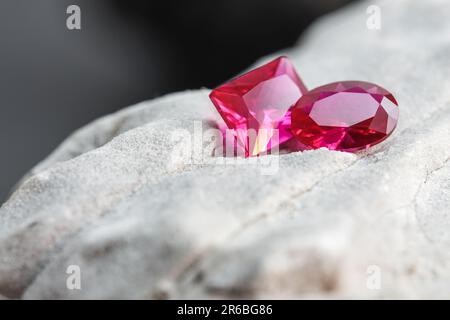 Die glitzernden natürlichen rosa Saphirsteine auf einer rauen Felsoberfläche Stockfoto