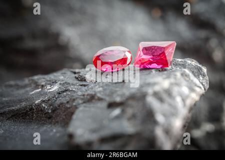 Die glitzernden natürlichen rosa Saphirsteine auf einer rauen Felsoberfläche Stockfoto