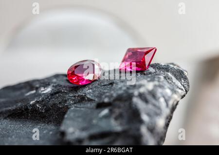 Die glitzernden natürlichen rosa Saphirsteine auf einer rauen Felsoberfläche Stockfoto