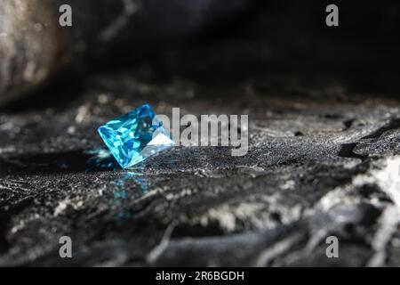 Ein glitzernder, blauer Saphir-Edelstein auf einer Felsoberfläche Stockfoto