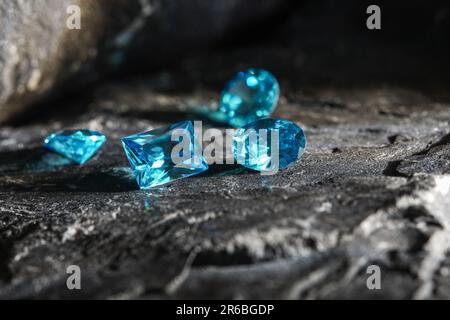 Die glitzernden natürlichen blauen Saphir-Edelsteine auf einer rauen Felsoberfläche Stockfoto