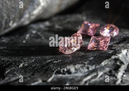 Die glitzernden natürlichen rosa Saphirsteine auf einer rauen Felsoberfläche Stockfoto