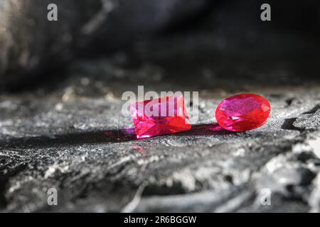 Die glitzernden natürlichen rosa Saphirsteine auf einer rauen Felsoberfläche Stockfoto