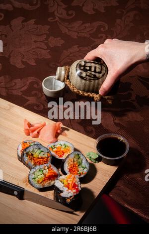 Traditionelle japanische Küche. Sushi-Brötchen auf einem Holzbrett Stockfoto