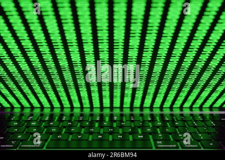 Halb geschlossener Computerbildschirm mit leuchtenden Binärzahlen auf der Tastatur des Laptops. Illustration der Internet- und Computerwelt Stockfoto