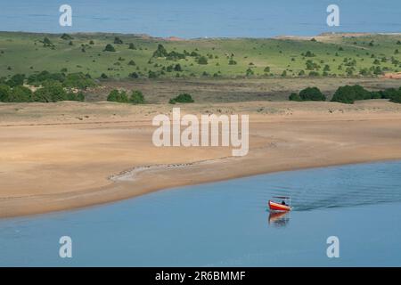 Ein Einzelboot in den ruhigen Gewässern der Lagune in den von Sidi Moussa-Oualidia RAMSAR geschützten Feuchtgebieten in der Nähe der Stadt Oualidia in Marokko Stockfoto