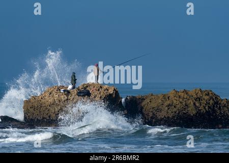 Fischer auf den Felsen in Oualidia in Marokko Stockfoto