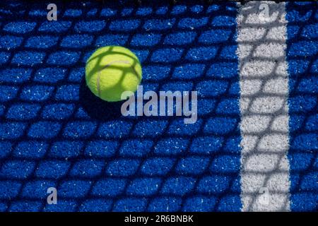 Ball im Schatten des Netzes auf einem blauen Paddle-Tennisplatz Stockfoto