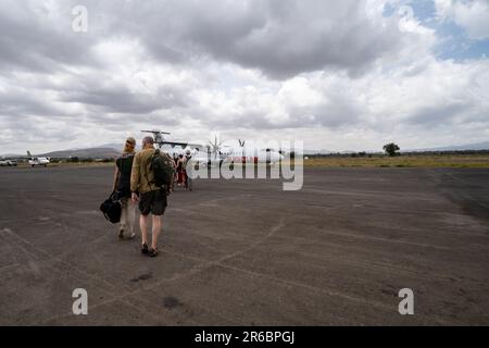 Arusha, Tansania - 14. März 2023: Passagiere steigen am Inlandflughafen von Arusha in ein kleines Flightlink-Flugzeug ein Stockfoto