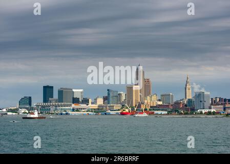 Die Skyline von Cleveland kann von einem Kreuzfahrtschiff auf dem Eriesee unter grauen Wolken gesehen werden, aber mit Sonnenlicht, das von der Plattform einfällt Stockfoto