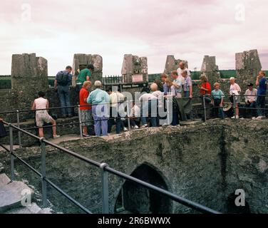 Irland. County Cork. Schloss Blarney. Besucher der Blarney-Steinzeremonie beim Küssen. Stockfoto