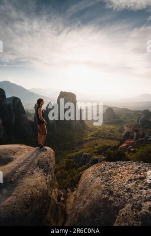 Ein Mann, der sich während seines Abenteuers in Griechenland vom wunderschönen Sonnenuntergang in den Felsklöstern Meteora inspirieren lässt. Stockfoto