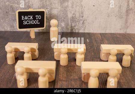 Stilleben in der Schule: Eine Tafel mit der Inschrift zurück zur Schule, ein Apfel und Blumen, Bücher und Buntstifte auf weißem Hintergrund Stockfoto