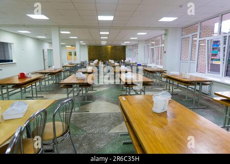 Stühle und Tische. Der Speisesaal in der Schule ist unter Quarantäne, Isolation. Stockfoto