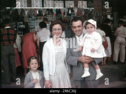 1950er – eine Familie im Urlaub posiert für ein Foto vor einem Souvenirverkäufer, Geschäften, einem 8-mm-Minox-Film-Diascan Stockfoto