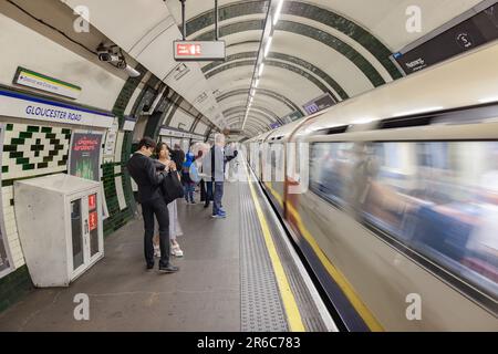 London, Großbritannien - 17. Mai 2023: Langzeitaufnahmen eines Zuges, der an einer U-Bahn-Station in der Gloucester Road ankommt Stockfoto