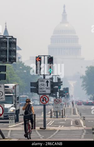 8. Juni 2023, Washington, District of Columbia, USA: Ein Radfahrer radelt in Washington unter gefährlichen Luftbedingungen die Pennsylvania Avenue hinunter. Trübe und gefährliche Dämpfe von fortwährenden Waldbränden in Kanada haben den Himmel über weite Teile des Nordostens verschlungen. Im Osten der USA wird die Luftqualität durch den Rauch gewarnt, der die legendären Skylines hinter den wehenden Orangendämpfen verschwinden ließ, was die Luftqualität für Millionen von Menschen verschlechterte. (Kreditbild: © Eric Kayne/ZUMA Press Wire) NUR REDAKTIONELLE VERWENDUNG! Nicht für den kommerziellen GEBRAUCH! Stockfoto