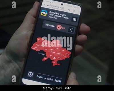 Kiew, Ukraine. 08. Juni 2023. Die Hand mit einem Smartphone mit einer offiziellen Karte der Flugwarnungen in der Ukraine zeigt, dass alle Regionen des Landes von 26 russischen Raketen bedroht sind. (Foto: Igor Golovniov/SOPA Images/Sipa USA) Guthaben: SIPA USA/Alamy Live News Stockfoto