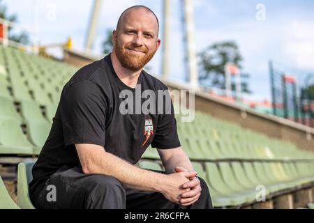 Berlin, Deutschland. 08. Juni 2023. American Football: Europäische Fußballliga, Media Day im Berliner Thunder, Friedrich-Ludwig-Jahn-Sportpark. Cheftrainer Johnny Schmuck vom Berliner Thunder sitzt auf einem Stand und lächelt. Kredit: Andreas Gora/dpa/Alamy Live News Stockfoto