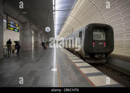 Ein Bahnsteig aus der Vogelperspektive, auf dem Menschen auf einen geparkten Zug zugehen Stockfoto