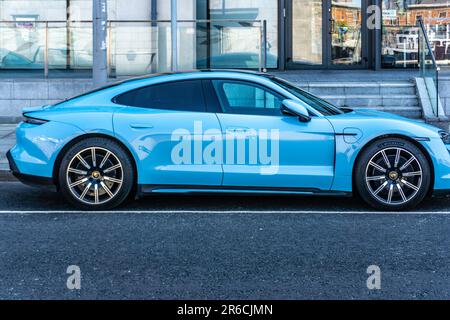 Ein blaues Elektrofahrzeug Porsche Taycan 4S, das in Dublin, Irland, geparkt hat. Stockfoto