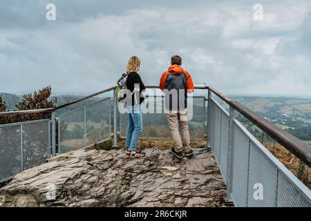 Ein paar Wanderer genießen gemeinsam den Blick auf die Natur. Herbst kalte Jahreszeit im Freien. Mann und Frau Rucksacktouristen auf der Aussichtsplattform. Freizeitaktivitäten Stockfoto