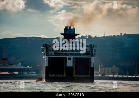 Die Schornsteine der Fähre geben Rauch ab, während sie den Hafen von Barcelona ansteuern. Schwefeldioxid- und Stickoxidemissionen machen den Hafen von Barcelona in Europa zum schlechtesten für die Luftverschmutzung. Stockfoto