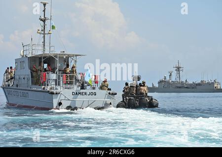 Spanische Marinesoldaten bereiten sich darauf vor, an Bord eines djiboutianischen Schiffes zu gehen, um während der Übung Bull Shark in Arta Beach, Dschibuti, am 3. Juni 2023 Besuche, Einstieg, Durchsuchungen und Beschlagnahmen zu üben. Bull Shark ist eine Krisenreaktions- und Personalwiederherstellungsübung, mit der die Kommunikation und Interoperabilität zwischen gleichgesinnten Partnern getestet werden soll. (USA Army National Guard Foto von SPC. Emily Held) Stockfoto